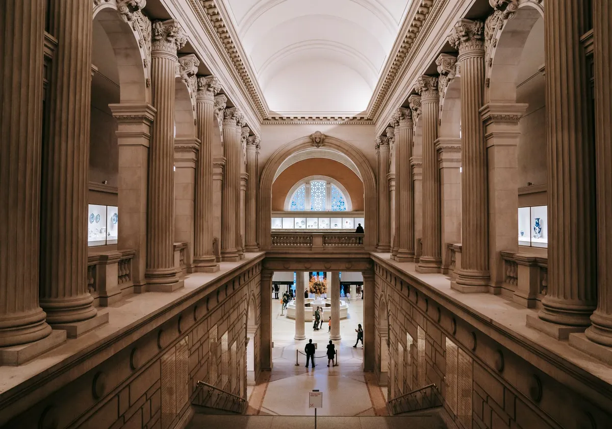 Majestic indoor view of museum with grand columns and arches, evoking elegance.